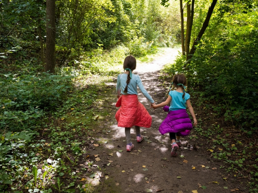Dve dievčatá na turistike v lese.