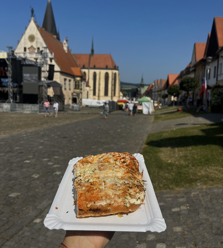 Jedlo na papierovej tácke pri pohľade na jarmočné stánky.